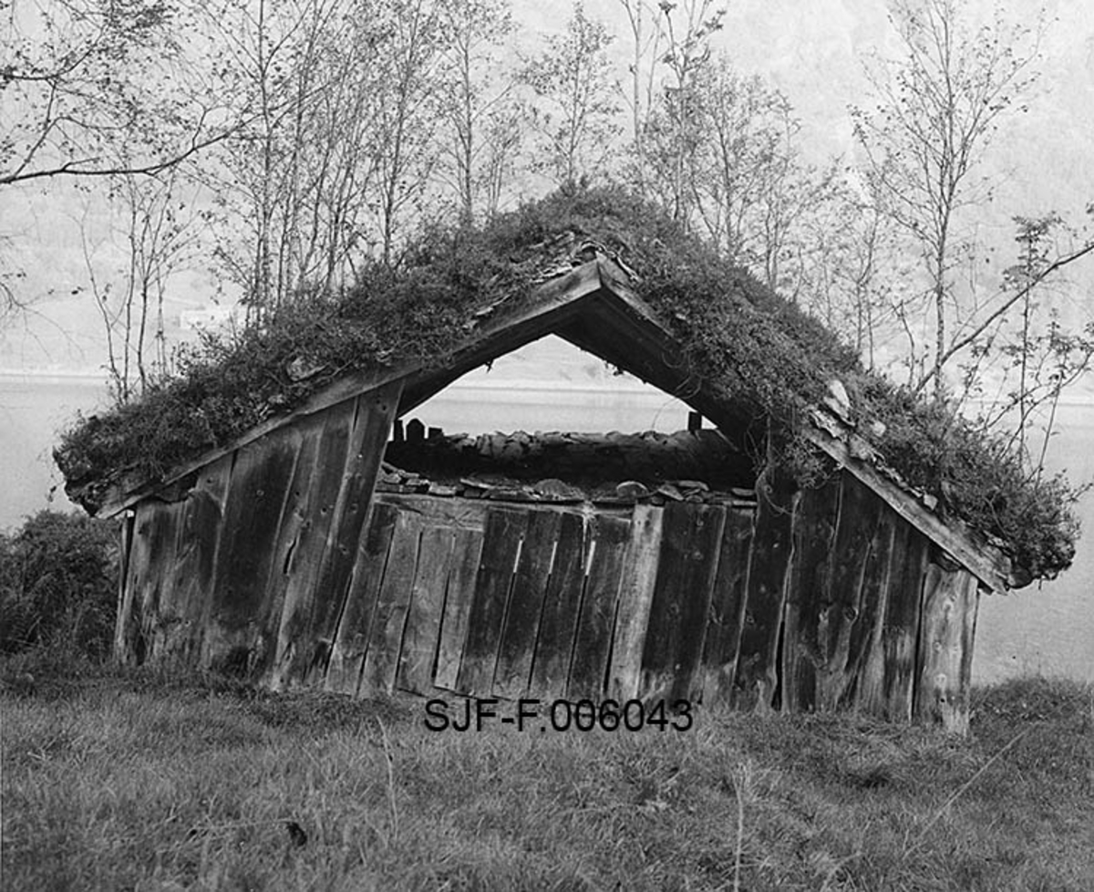 Naustet til Nikolai J. Gjesdal (1889-1973) ved Vassenden i Jølster i Sunnfjord i Sogn og Fjordane.  Fotografiet er tatt fra oversida av bygningen, midt imot den øvre (bakre) gavlen, med Jølstervatnet (Jølstravatnet) i bakgrunnen.  Naustet er en umalt, bordkledd stavkonstruksjon med torvtekt sperretak.  Gavlveggen som vender mot fotografen er bordkledd opp til beiten, men åpen i røstet.  På taket vokste det en god del lauvtrær da fotografiet ble tatt, noe som vel tyder på at det var ei stund siden taket ble lagt om da dette fotografiet ble tatt i 1968.  Dette året ble Nicolai Gjesdals naust demontert og flyttet til Norsk Skogbruksmuseums friluftsmuseum på Prestøya i Elverum.  Fotografiet er antakelig tatt med sikte på at det skulle kunne være til nytte når konstruksjonene skulle gjenoppføres på ny tomt. 

Jølsternaustet er 790 centimeter langt og 456 centimeter bredt og har følgelig ei grunnflate på 36 kvadratmeter.  På gavlen mot vassdraget er rafthøyden 217 og mønehøyden 365 centimeter.  På den bakre eller vestre gavlen er rafthøyden 125 og mønehøyden 258 centimeter. 