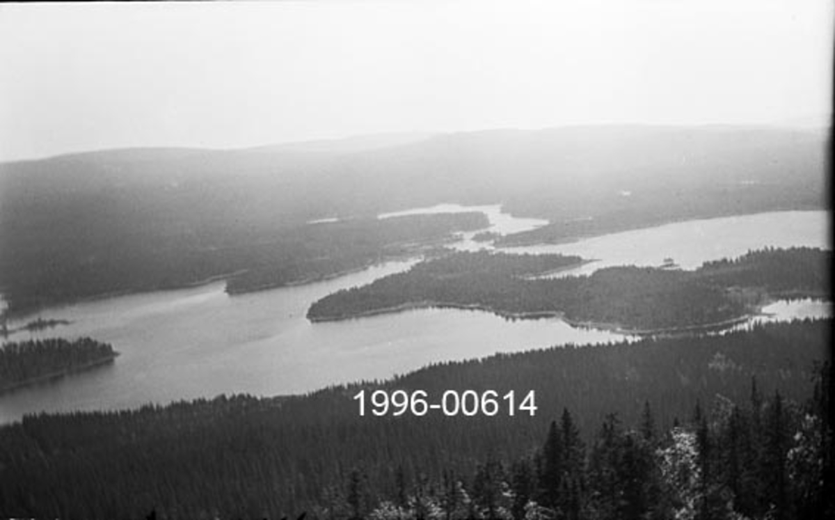 Utsikt fra Skjerveknatten skogbrannvaktstasjon i Gran på Hadeland (Oppland). Dette anlegget lå ved Våjevann, cirka 670 meter over havet.  Brannvaktstasjonen ble bygd i 1933 med midler fra forsikringsselskapet Skogbrand.  Det var imidlertid Gran Almenning som eide og drev stasjonen. 

Utsiktsfotografiet er tatt fra Skjerveknatten og østover mot nedenforliggende innsjøer og skogtrakter.  Vi ser antakelig innsjøene Våja, Grøa og Skjellbreia omgitt av svære barskogvidder. 

