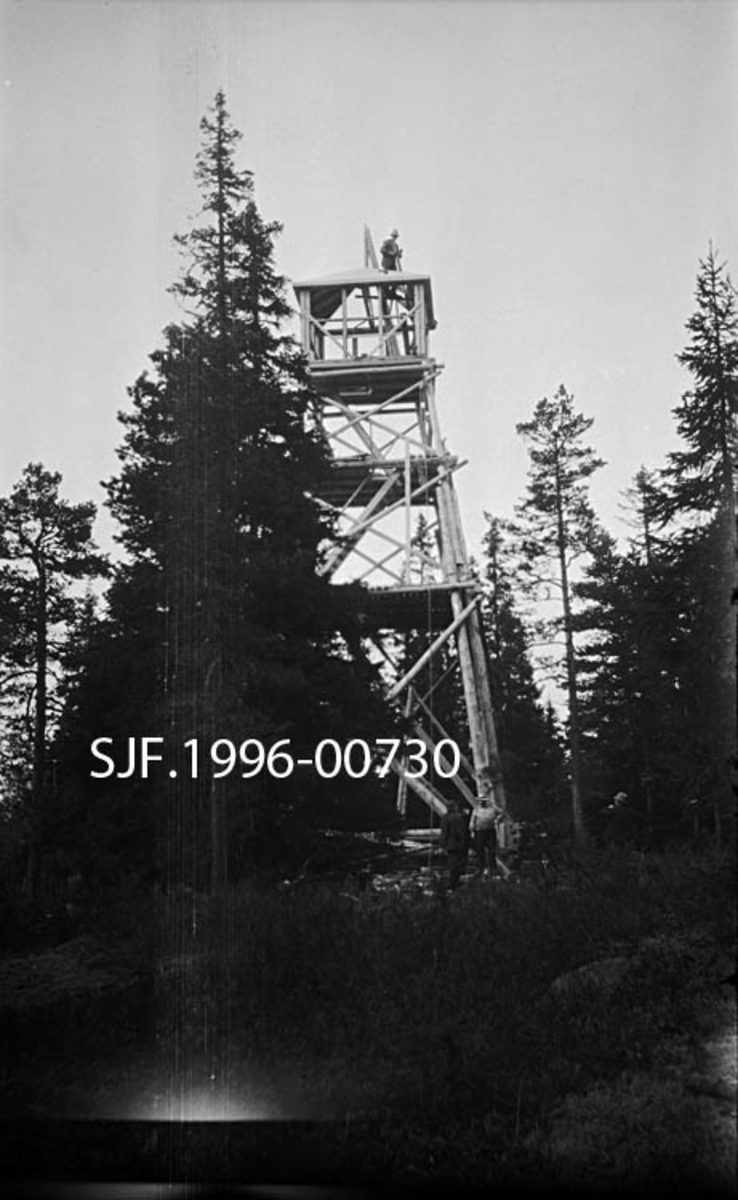 Brannvaktårnet ved Lundbergseteter fotografert i 1936.  Fotografiet viser et stolpetårn av vanlig type.  Tårnet har noenlunde kvadratisk grunnplan.  Det er bygd av stolper som er reist i en bratt, pyramidal form med stolpekryss i tre nivåer på alle fire sider som avstiving.  Adkomsten til utkikkshytta på toppen skjedde via to horisontale plattformer og stiger opp til ei luke i hyttegolvet.  Da fotografiet ble tatt var tårnet under oppføring.  Bindingsverkshytta hadde ennå ikke fått bordkledning og vinduer.  En mann arbeidet på pyramidetaket, der det ble montert lynavleder.  Tårnet ble bygd på et høgdedrag med litt glissen barskog. 