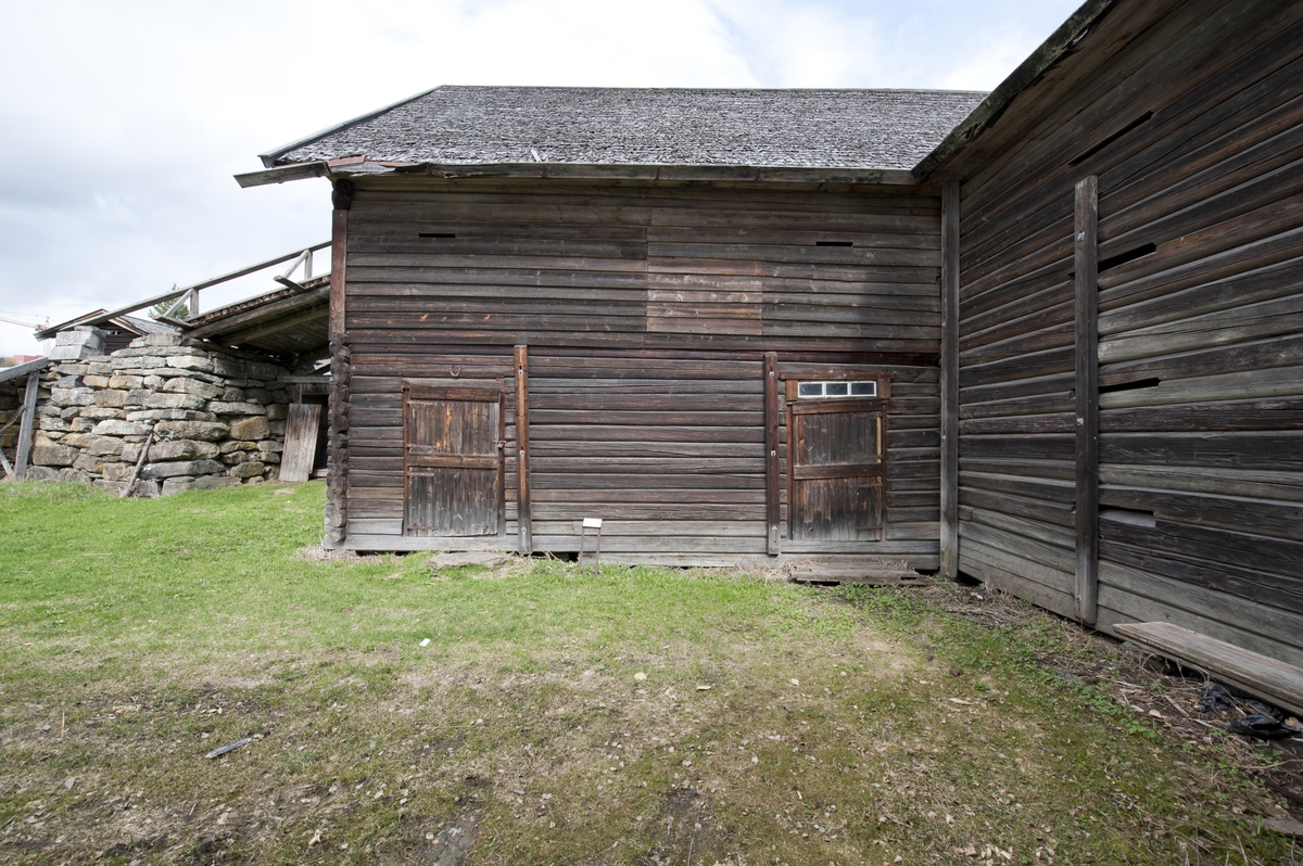 Låve med to fløyer i vinkel, laftet: Bygningen har saltak tekket med flis. Kjøringa går gjennom hele bygningen og har sin begynnelse over stallen i nord. Dette er et tidlig eksempel på en enhetslåve der mange funksjoner er samlet under et tak. Stallen har innredning for fem hester med krybbe og foringsgang. På langsiden inn mot tunet er det oppført et hus for hestevandring. Det har pyramideformet tak som hviler på stolper.
