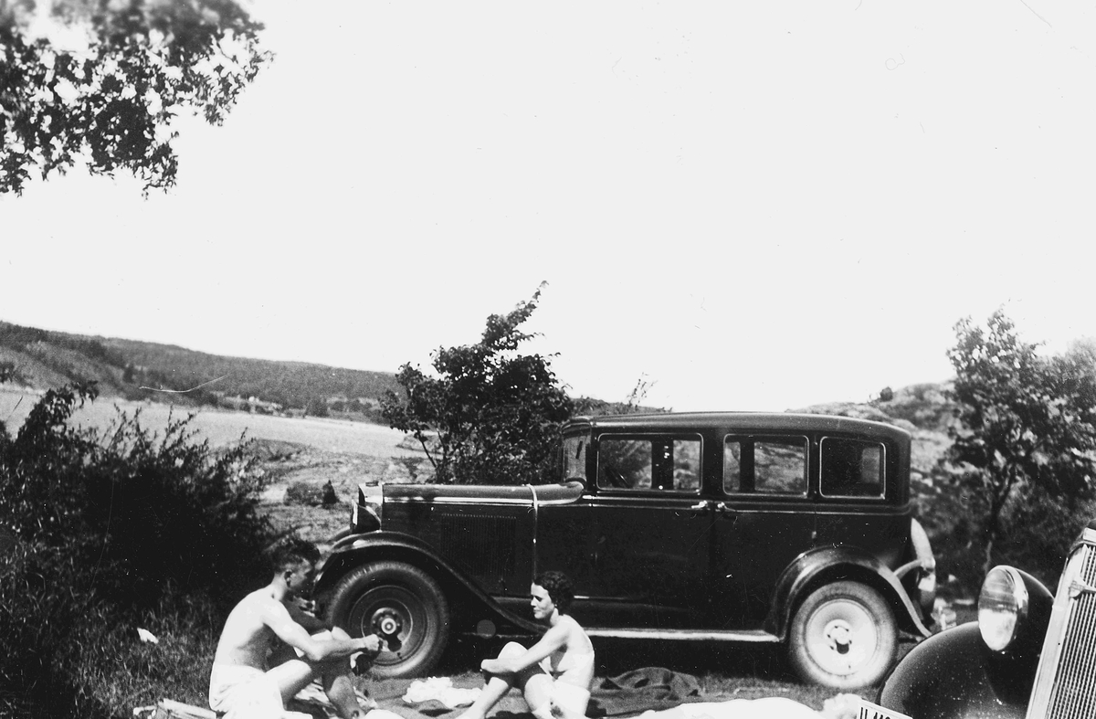 Else Getz Hansen og Herman Hansen er på biltur og har rastepause ved ei strand på Hamar. Har sommerklær. (Ikke Rjukan/Tinn)