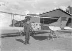 Porträtt av löjtnant framför flygplan Albatros SW 20 nr 750. Flygplansstjärten är uppställt på bock framför hangar på Malmen.