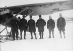 Grupporträtt vid provflygavdelningen i Kiruna. Sex män vid flygplan FVM J 23 på skidor.