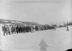 Inspektion på flygstationen i Östersund, vintertid, 1926. Militärer på rad. I bakgrunden syns flygplan.