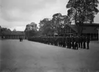 Inspektion av manskapet. Militärer uppställda på rad på lägerområdet F 3 Malmen, 1932.