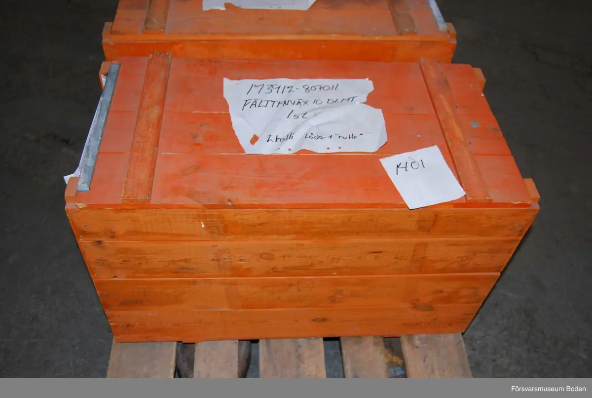 Nedpackad i orange transportlåda av trä.