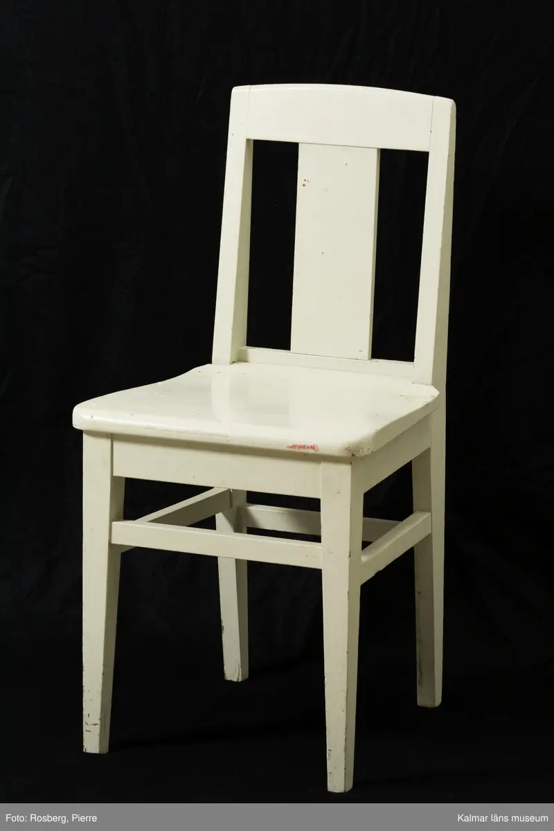 KLM 31908:1-3. Stol, skolstol. 3 stycken. Stol i furu, vitmålad. Rygg med vertikal, rektangulär ryggbricka, raka ben med sidoslåar, högre framslå och lägre bakslå.