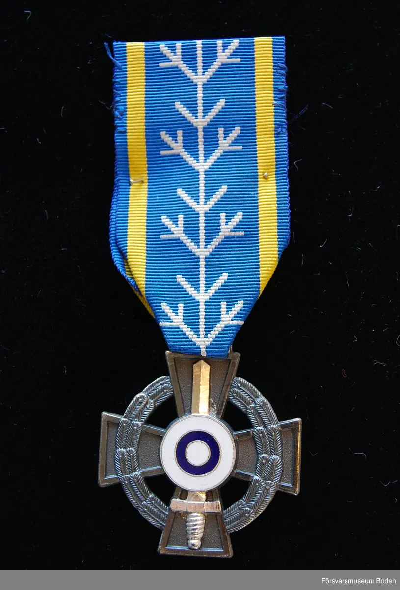 Tavla med uppsatta medaljer på svart sammet. Har tillhört Karl Hjalmar Lindskog, finlandsfrivillig 1939-1940. Från vänster på bilden:
1. Lapplands kors, stort, brons. Urkund finns i pärm under FMB.002361.
2. Lapplands kors, litet, brons.
3. Vinterkrigets minnesmedalj, brons.
4. Svenska frivilligkorset, litet, järn.
5. Svenska frivilligkorset, stort, järn. Urkund finns i pärm under FMB.002361.