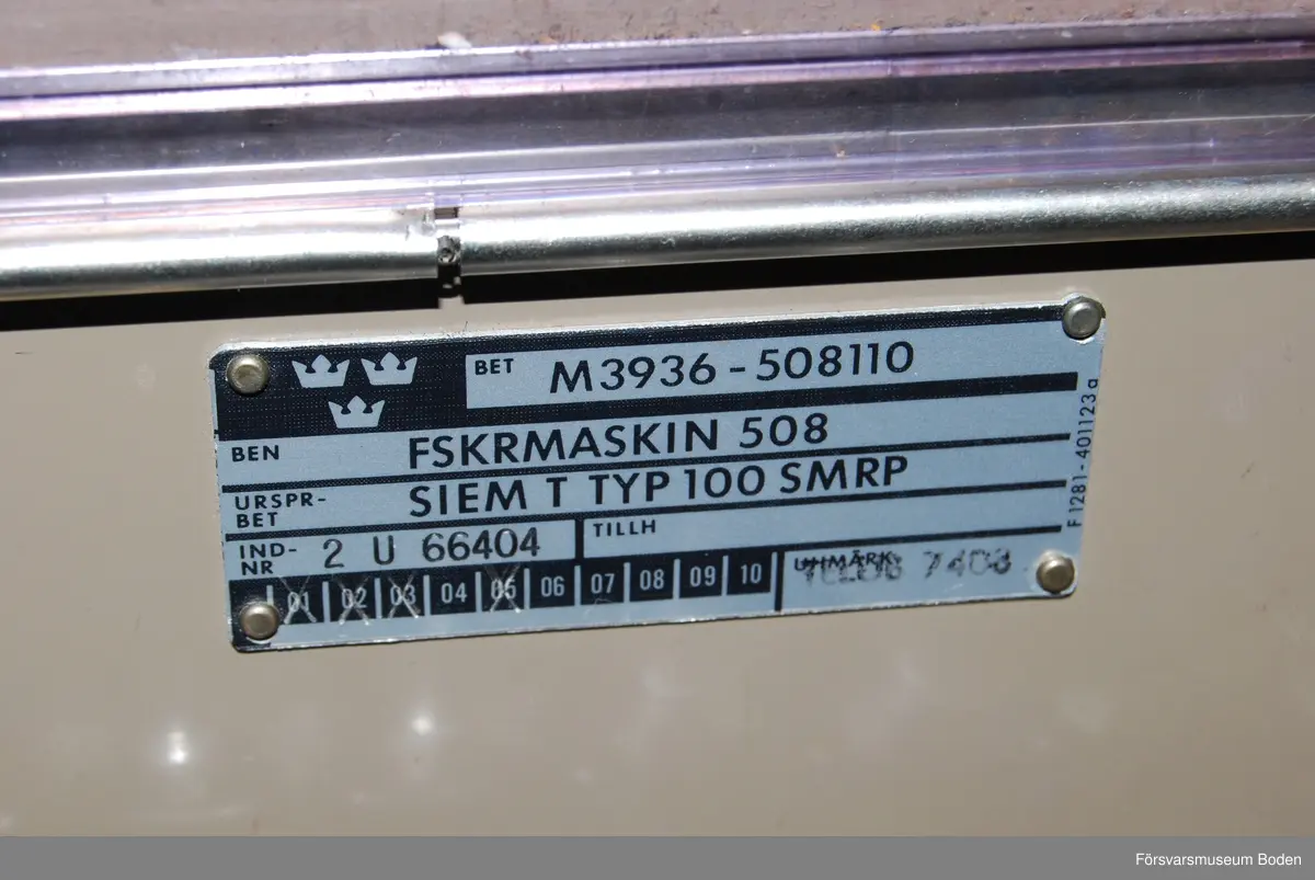 Står på rullbord, transportlådan saknas. Ursprungsbeteckning Siemens typ 100, individnr 2 U 66404. Pappersrulle och remsa är monterade. Enligt etiketter inuti locket var sista översyn 14/1 1982, och föregående 08 1974. Har använts vid AF 1 i Boden.