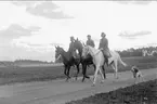 Kan vara Ingrid och Peter samt sonen Peter född 1926. Ryttaren i mitten förefaller vara minst 15 år. Bilden är i så fall tagen mellan 1941-47 i Skövde. Uppgiftslämnaren ryttm. Cleas Lewenhaupt, Claesborg. Kortet är taget på fältet söder K 3 kasern.