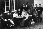 Gruppbild. Kafferep utanför Sylstugan vid invigningen 1897. I förgrunden flicka i folkdräkt. 
Enligt påskrift på baksida: 