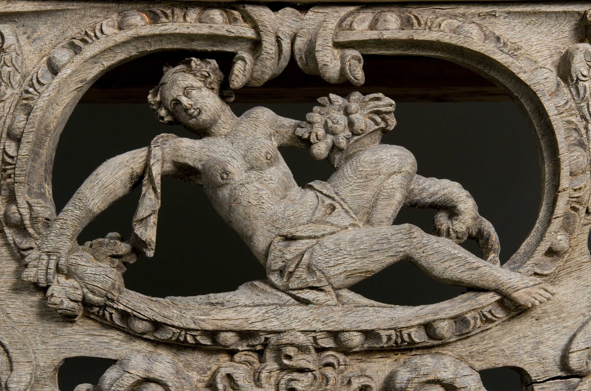 Rektangulært skap med skåret ornamentikk i flere deler. Øvre skap med to dører og gesims. Nedre skap med en klaff fremstilt som to dører. Skapdelene står på en sokkel med fire ben. Tympanon på øvre skap. Skapet ble opprinnelig brukt som skjenk med åpen klaff for å servere drikkevarer til gjester.
På overskapet i dørfyllinger er utskåret motiv fra gamle testament: "Samsons kamp med løven" og "Samson bærer bort Gazas byport". På underskap i fyllinger: "Samson slår filisterne med asenkjeven" og "Samson og Dalila". Dørene blir flankert av hermenpilaster. Mellom fyllinger på overskap aedikula med dyden "kjærlighet".  Som karyatide og atlant to utskårete figuerer "Adam og Eva" ved overskap. 
Klassiske profiler med eggstav, perlestav og tannsnitt. Beslagverkornament på skapsidene, gesimsens underside og profil på underskap. 
Utskårete hoder av løver, engler, kvinner, masker på gesimsens underside og profil på underskap. Sidebrett med hermer, portretter i medaljonger og beslagverk. Sokkelen består av dreide og utskårete ben, holdt av en ramme, Forsidens blending er dekorert med utskårete figurer og ornamenter i ørebruskstil.
Flere deler er sekundære.