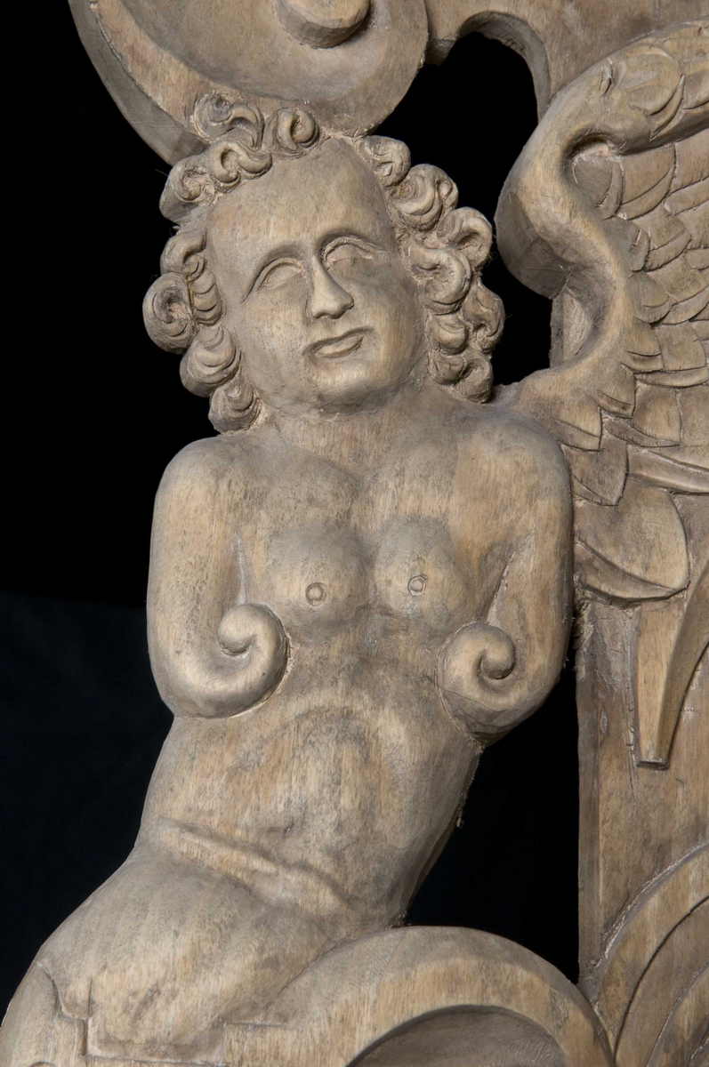 Rektangulært skap med skåret ornamentikk i flere deler. Øvre skap med to dører og gesims. Nedre skap med en klaff fremstilt som to dører. Skapdelene står på en sokkel med fire ben. Tympanon på øvre skap. Skapet ble opprinnelig brukt som skjenk med åpen klaff for å servere drikkevarer til gjester.
På overskapet i dørfyllinger er utskåret motiv fra gamle testament: "Samsons kamp med løven" og "Samson bærer bort Gazas byport". På underskap i fyllinger: "Samson slår filisterne med asenkjeven" og "Samson og Dalila". Dørene blir flankert av hermenpilaster. Mellom fyllinger på overskap aedikula med dyden "kjærlighet".  Som karyatide og atlant to utskårete figuerer "Adam og Eva" ved overskap. 
Klassiske profiler med eggstav, perlestav og tannsnitt. Beslagverkornament på skapsidene, gesimsens underside og profil på underskap. 
Utskårete hoder av løver, engler, kvinner, masker på gesimsens underside og profil på underskap. Sidebrett med hermer, portretter i medaljonger og beslagverk. Sokkelen består av dreide og utskårete ben, holdt av en ramme, Forsidens blending er dekorert med utskårete figurer og ornamenter i ørebruskstil.
Flere deler er sekundære.