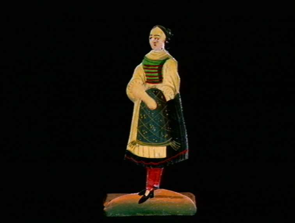 Figurer i papir med trefot i form av husfasader, tær, dyr og mennesker. Tilhørende eske.