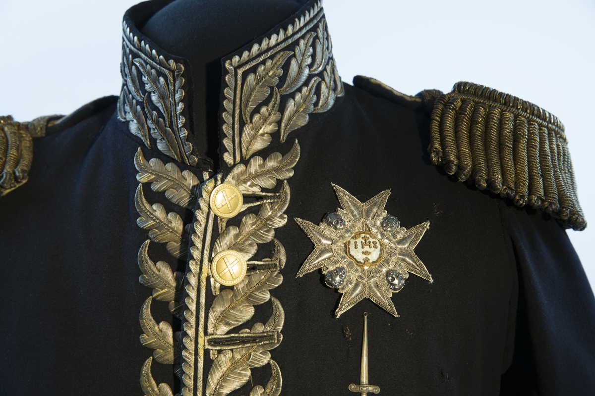 Mørkblå frakk med dekor av metallbroderi.