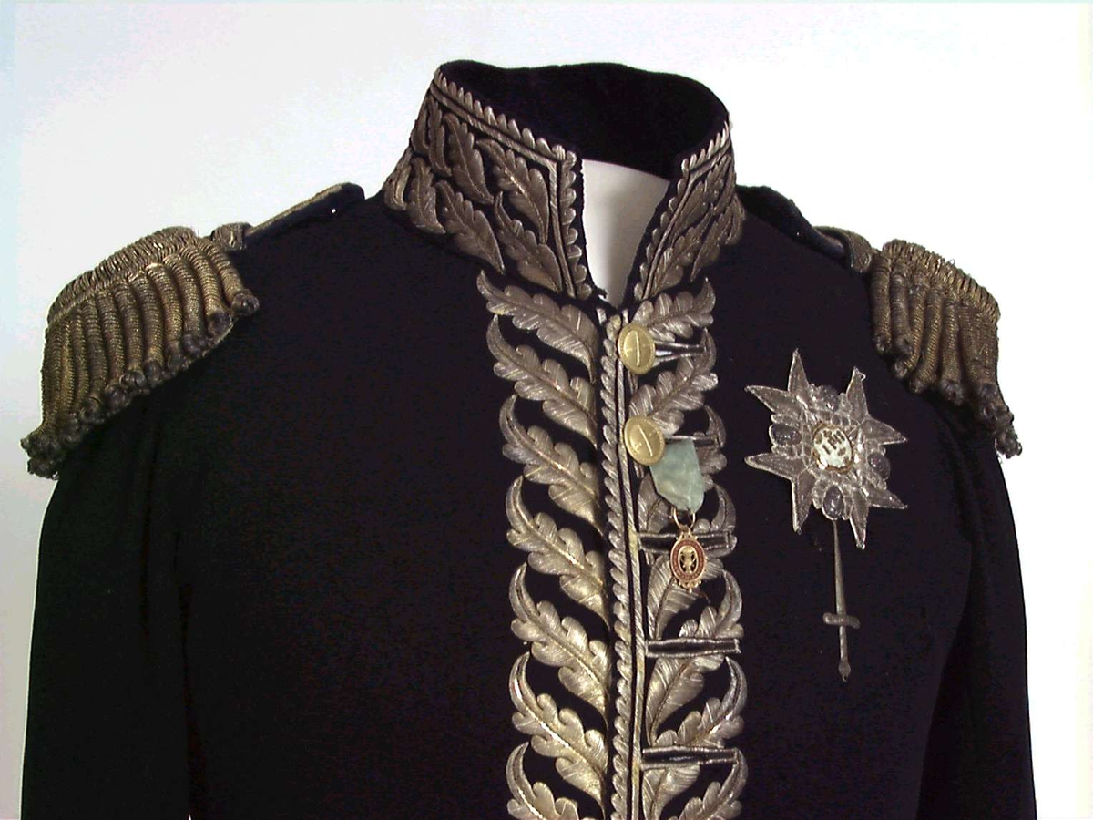 Mørkblå frakk med dekor av metallbroderi.