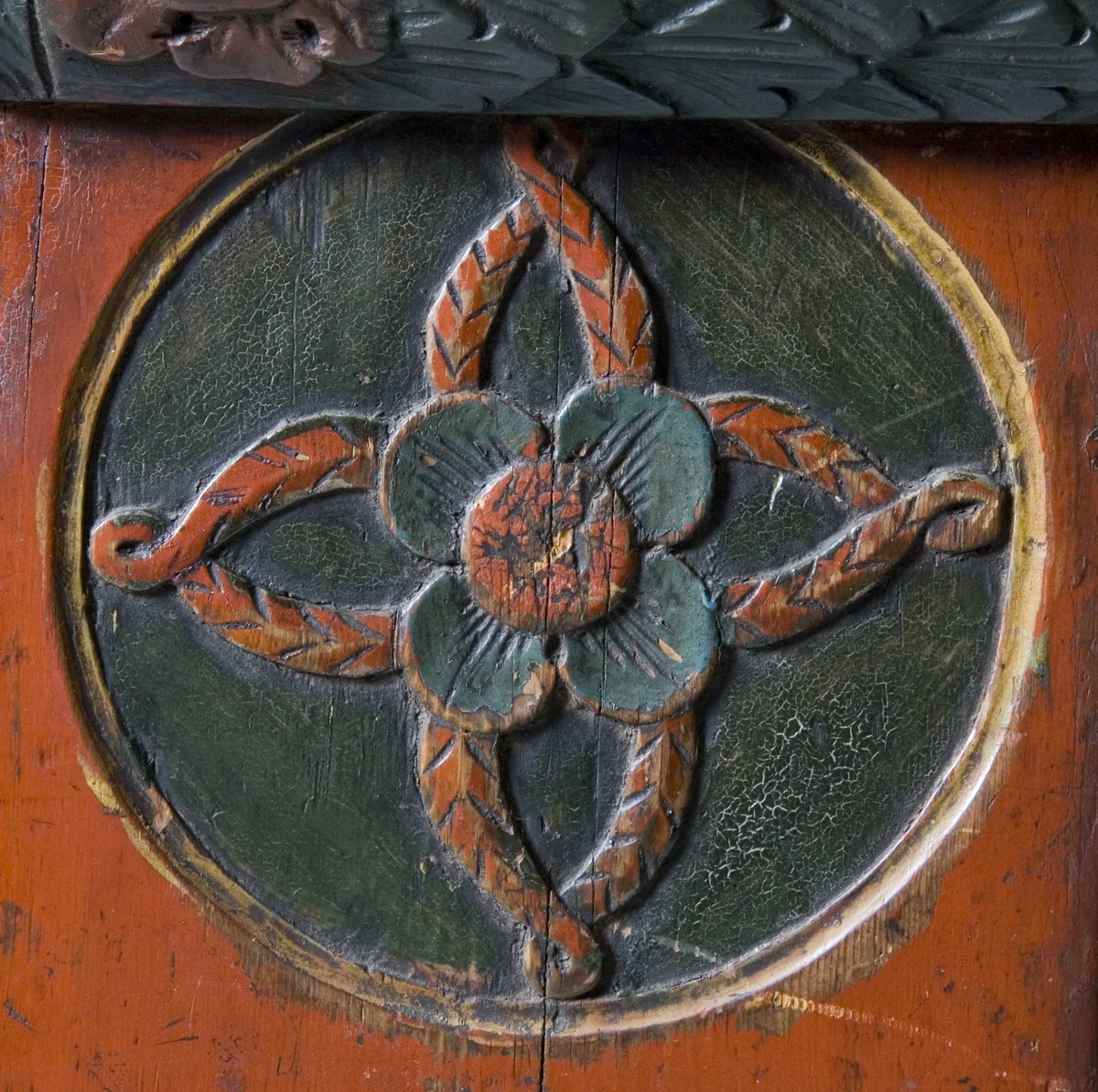 Framskap på fire dreide ben. Dekorert med marmorering, utskårne klassisistiske motiv og krone med gjennombrutt akantusranke.