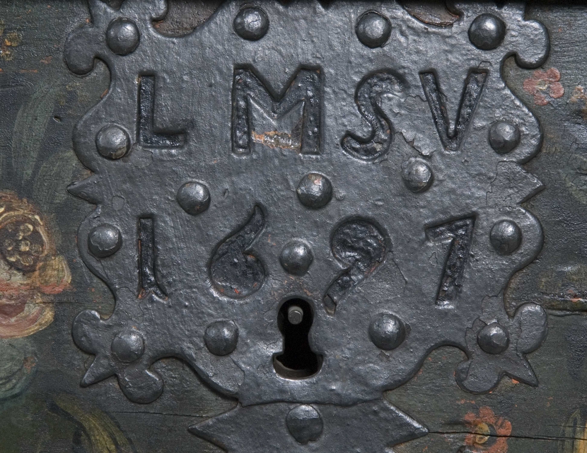 Kiste med buet lokk og heldekkende rosemaling, hvorav mye er senere tilføyelser eller restaureringer. Kulebena er også sekundære.