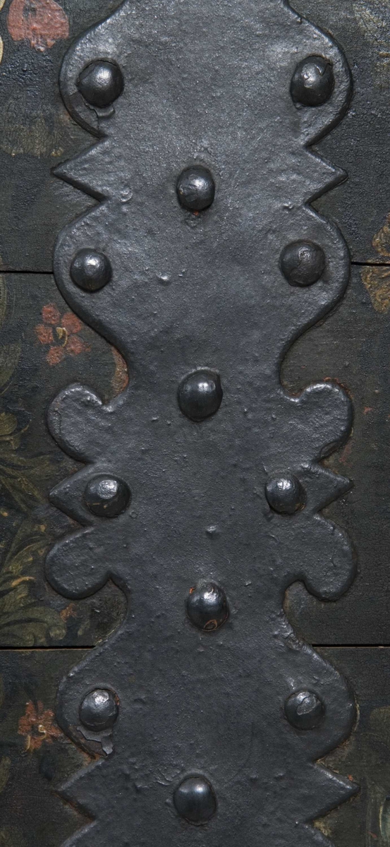 Kiste med buet lokk og heldekkende rosemaling, hvorav mye er senere tilføyelser eller restaureringer. Kulebena er også sekundære.