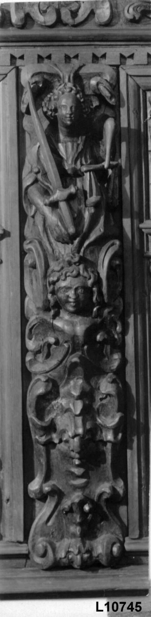Himmelseng i fem deler, sidevanger, kortsider og tak. Kortsidene er rikt utskåret med Adam og Eva som sengestolper i front. Flere figurer og ornamentale utskjæringer.