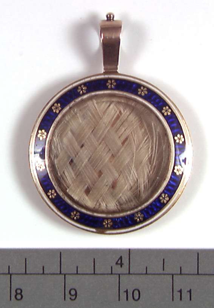 Medaljong med flettet hår og tørkede blomster inni.
