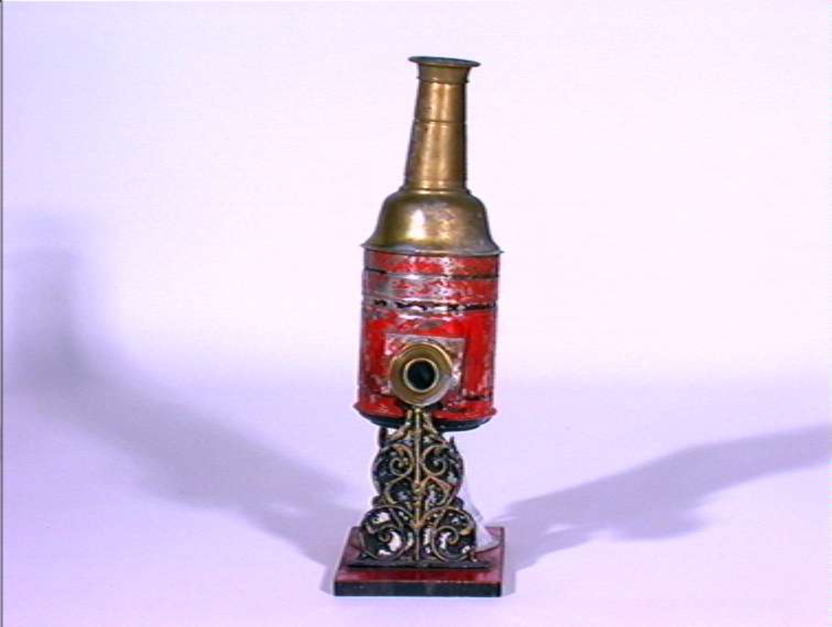 Lysbildefremviser i flere deler med parafinlampe. 12 glassplater med forskjelliger motiver i lysebrune rammer hører til.