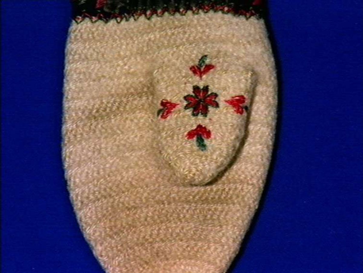 Hvite votter i nålebinding med dekor ab broderi og applikasjon.