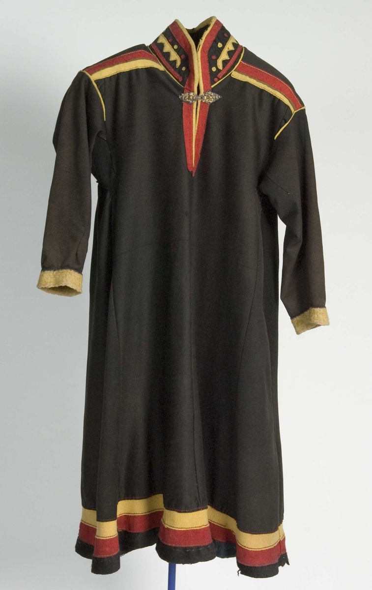 Svart kofte av klede med dekor av gult, rødt og beige klede.