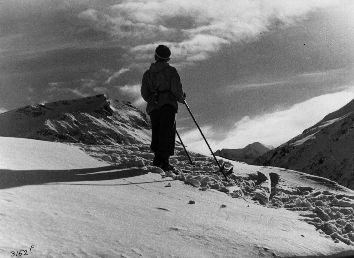 Skiløper ved Styggehø i Jotunheimen med snødekte fjell.