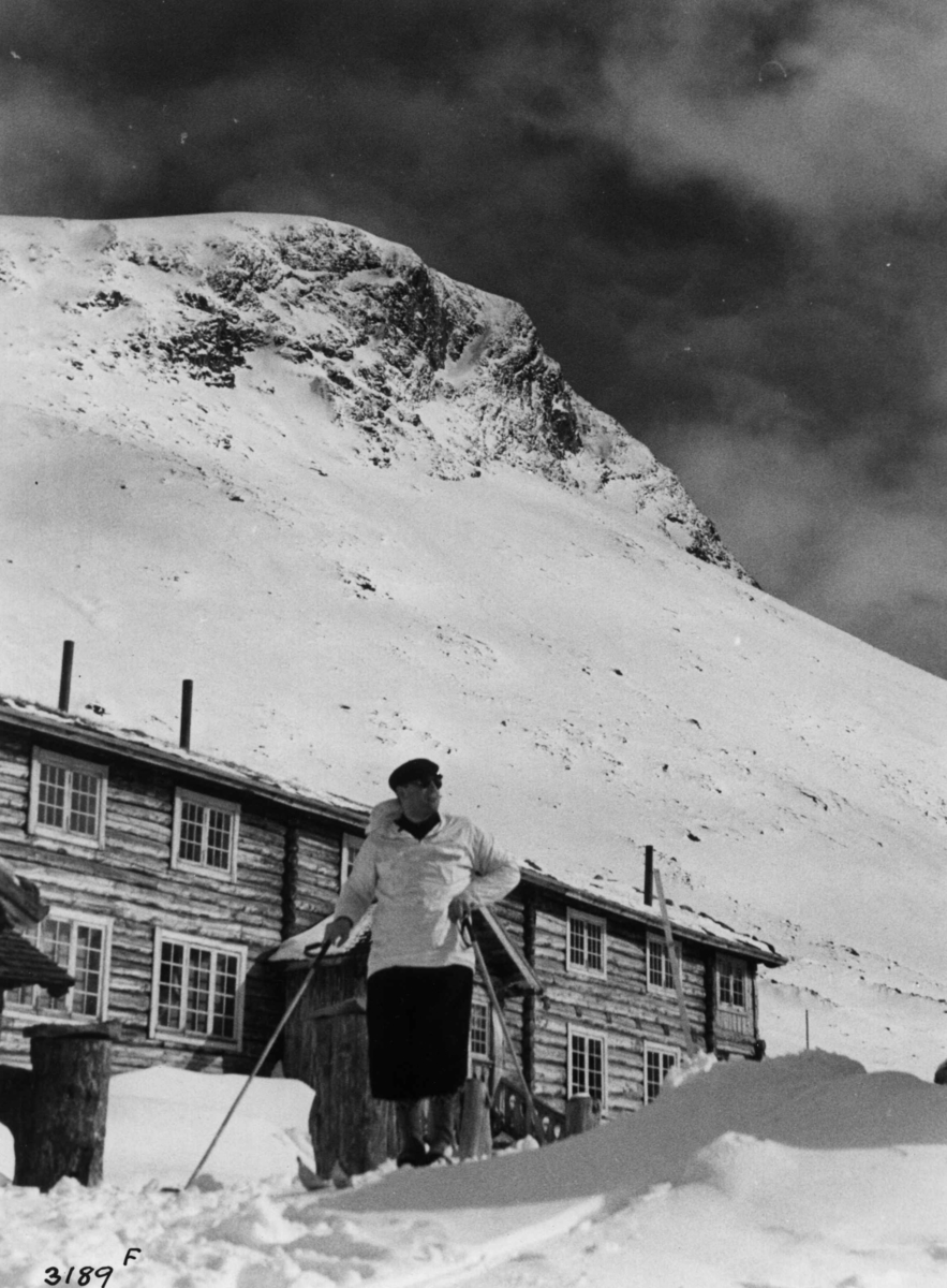 Skiløper ved Spiterstulen i Visdalen i Jotunheimen med snødekte fjell.