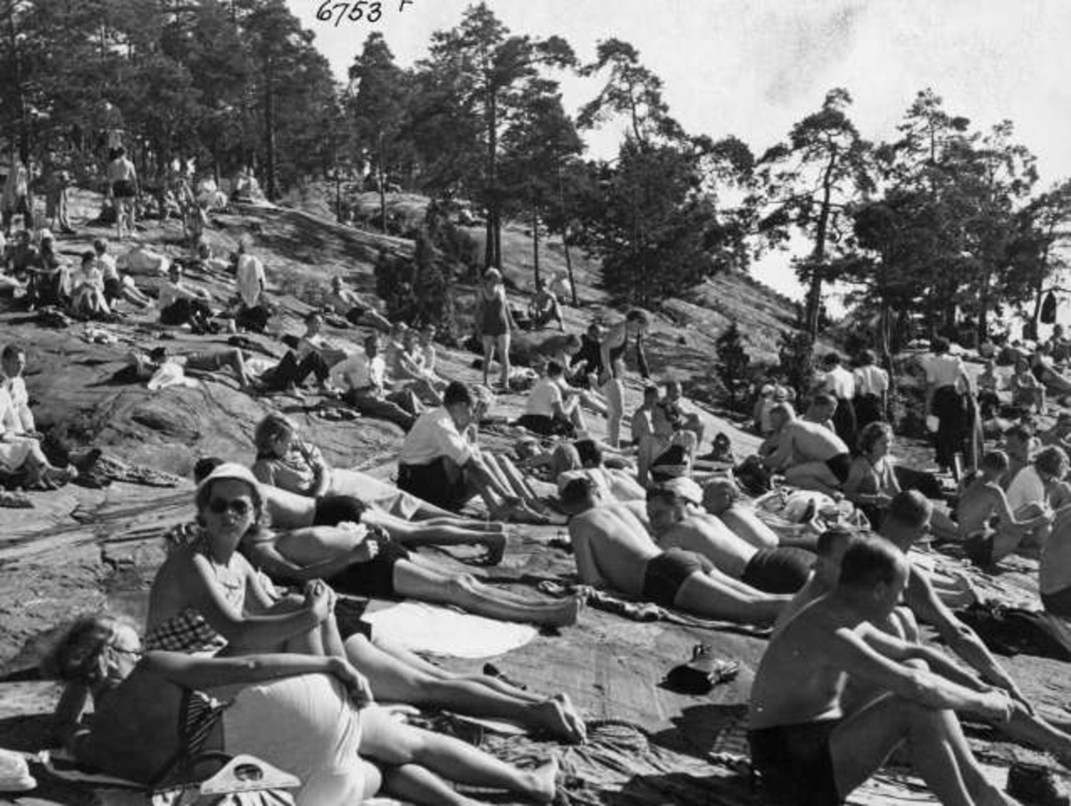 Strandliv med badegjester som soler seg på svaberget ved sjøen på Ingierstrand bad utenfor Oslo.