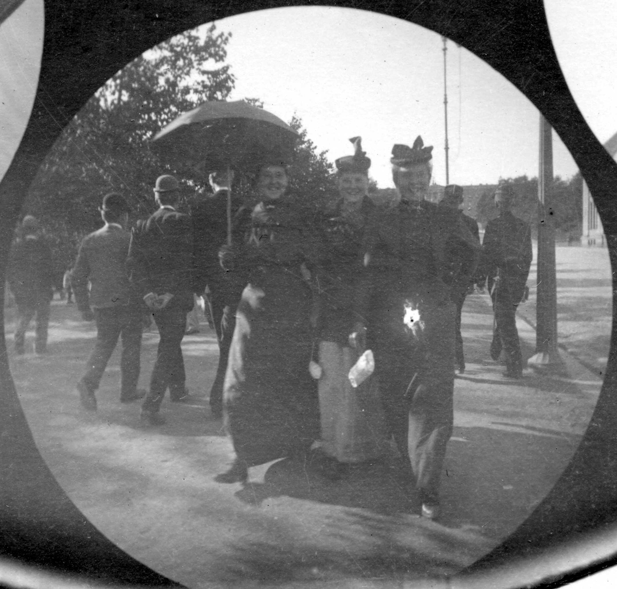 Mennesker spaserer langs Karl Johans gate, Oslo. Tre kvinner sammen midt i bildet.
