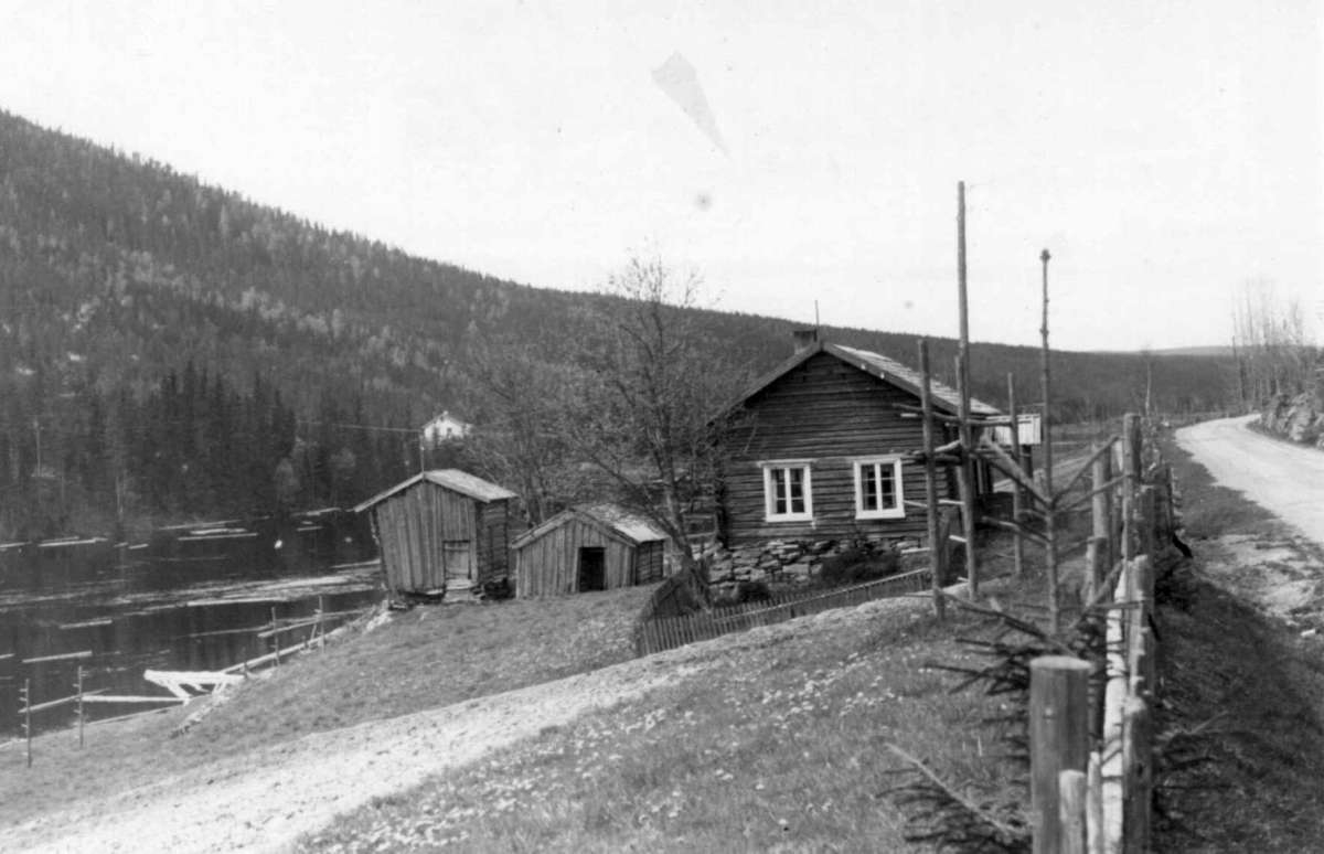 Nordgal'n Kolos, Trysil, Hedmark 1950. Stue, stabbur og skåle, ved elv.