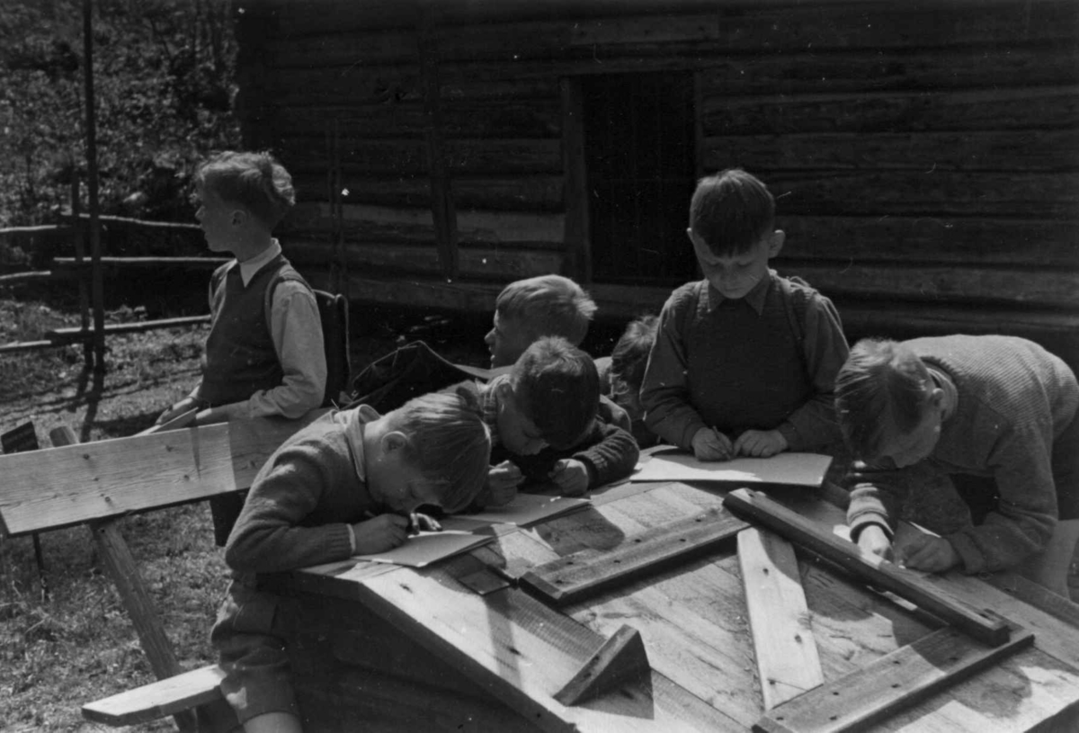 Skolegutter tegner i Østerdalstunet på Norsk folkemuseum, 1951.