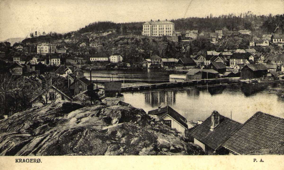 Postkort. Jule- og nyttårshilsen. Fotografisk motiv. Svart/hvitt. Oversiktsbilde. Motiv fra Kragerø. Stemplet 23.12.1905.