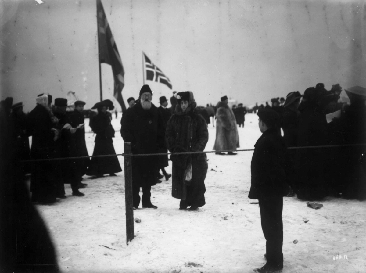 Frognerkilen, Oslo 1909. Vintermotiv. Fra kappritt. Dronning Maud i samtale med hoffjegermester Fearnley.
Publikum.