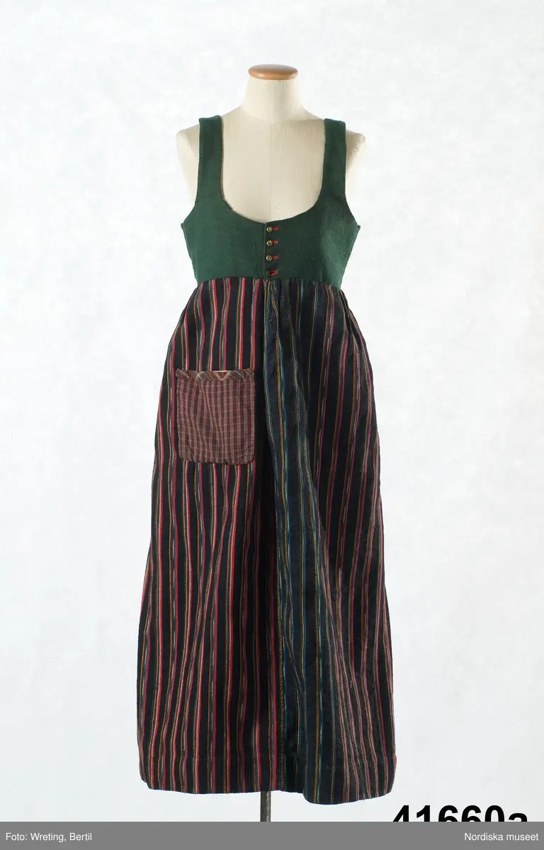 a. Livstyckskjol med liv av grön vadmal och randig halvyllekjol
b.Kvinnotröja, kort modell av svart kläde, med litet skört.
c. Halskläde av rödbottnad kattun
d. Halskläde av röd/gulrutig bomullslärft
e. Kjolväska  av svart kläde med applikationer av vadmal med tenntrådskonturer.
g: 1-4,  mjuk bindmössa av ljusblå sidenbrokad med vita spetsbandsmönster samt blommönster i rosa, mörkrött, vitt och grönt mm.

Dräktdelarna förefaller att vara från något olika tider, och sammansatta för att bli en hel dräkt vid insamlandet till museet. För att illustrera ett äldre dräktskick på orten. 
/Berit Eldvik 2012-02-14