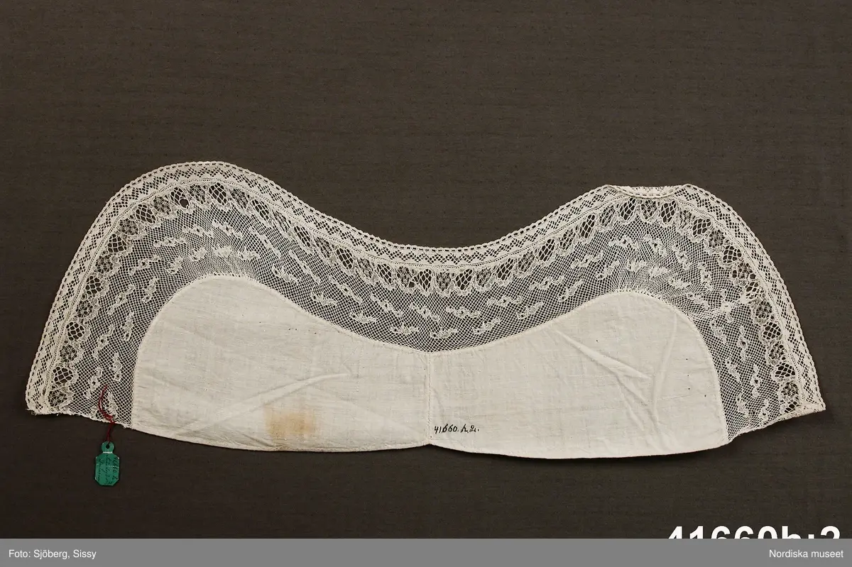 a. Livstyckskjol med liv av grön vadmal och randig halvyllekjol
b.Kvinnotröja, kort modell av svart kläde, med litet skört.
c. Halskläde av rödbottnad kattun
d. Halskläde av röd/gulrutig bomullslärft
e. Kjolväska  av svart kläde med applikationer av vadmal med tenntrådskonturer.
g: 1-4,  mjuk bindmössa av ljusblå sidenbrokad med vita spetsbandsmönster samt blommönster i rosa, mörkrött, vitt och grönt mm.

Dräktdelarna förefaller att vara från något olika tider, och sammansatta för att bli en hel dräkt vid insamlandet till museet. För att illustrera ett äldre dräktskick på orten. 
/Berit Eldvik 2012-02-14