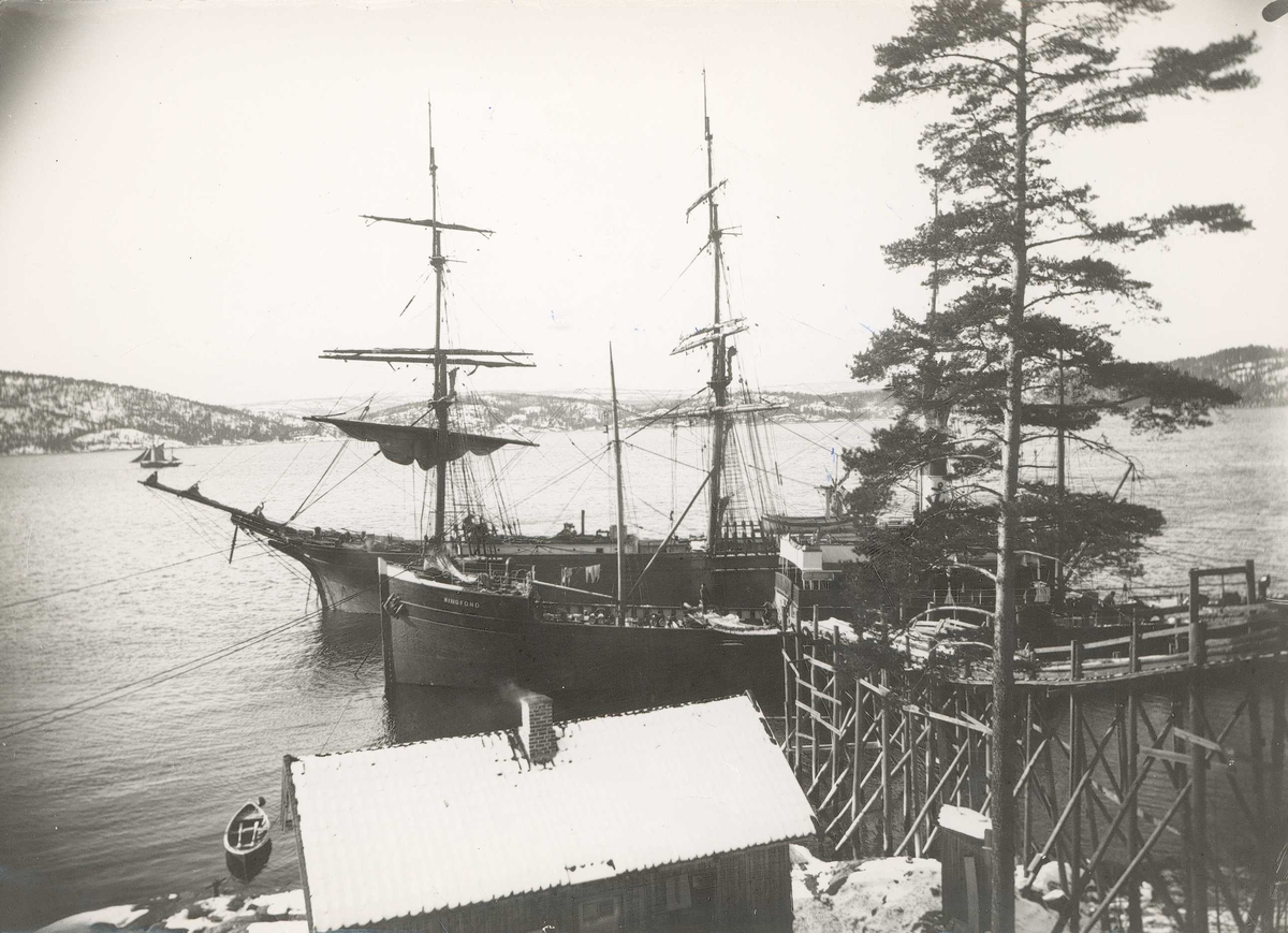 Islasting ved Sønderstøen i Frogn nær Nesodden i Akershus i 1907. Seil- og dampskip, D/S "Ringfond", ved land med reisverk i tre med renne for lasting av isblokker fra land.
Fra serie tatt av iseksportør Axel Quinsgaard Wiborg (d. 1944).