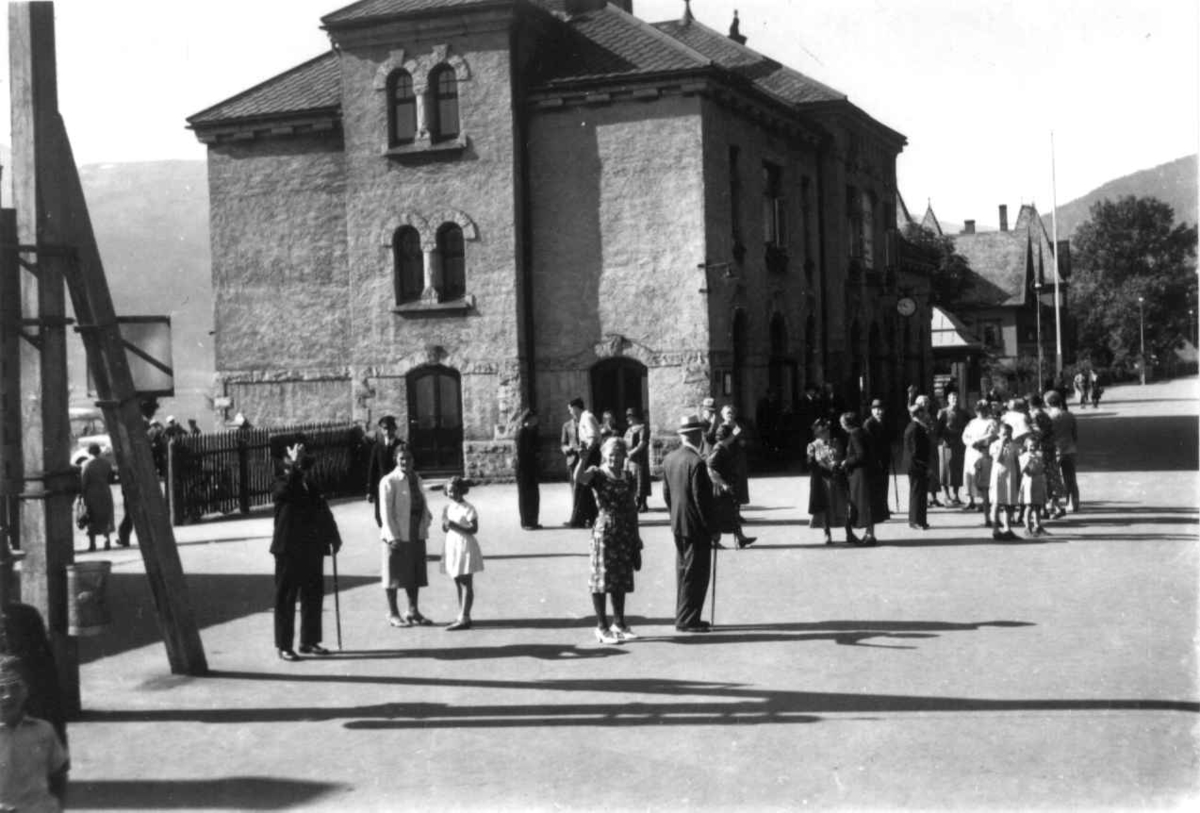 Voss jernbanestasjon 1939. Foran stasjonsbygningen. Passasjerer på perrongen.