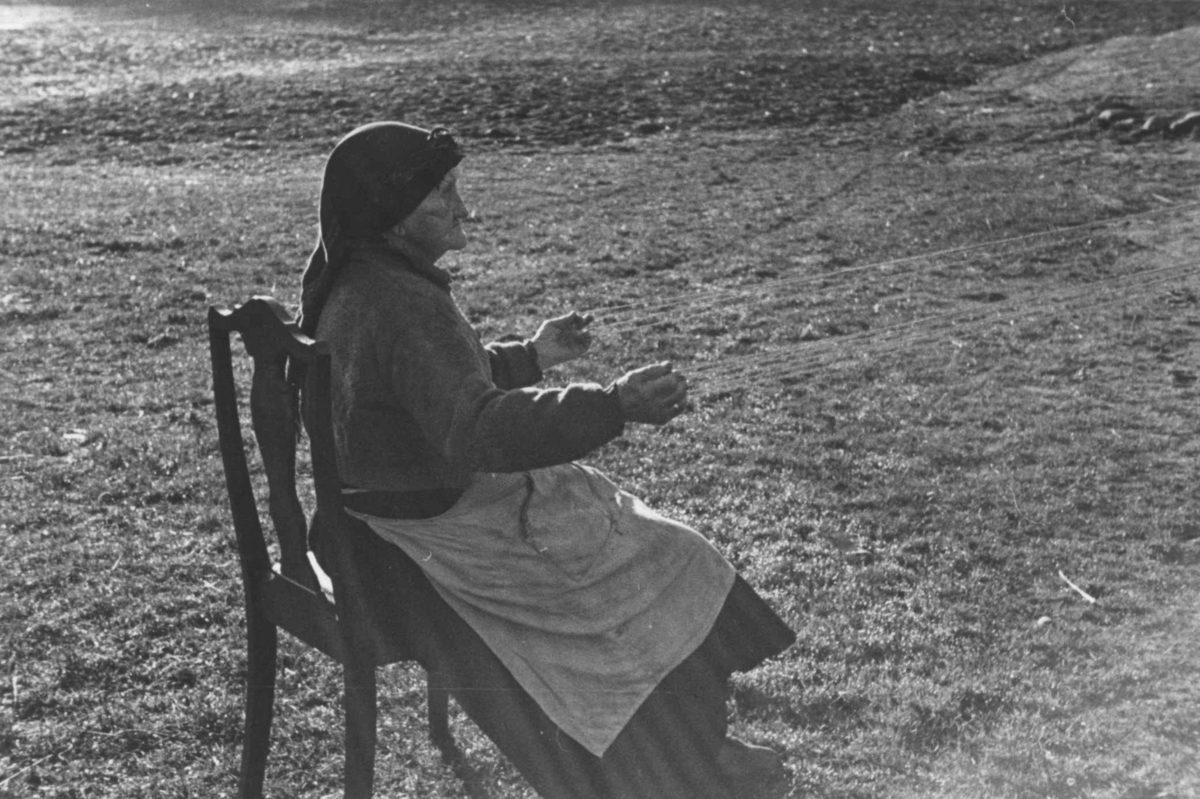 Bondekone Kristi Espeli og datteren lager snor til å ha nederst på stakk og kjoler. Åseral, Vest-Agder 1943.