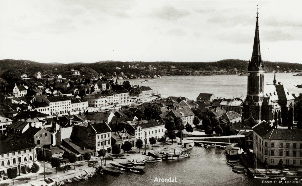 Arendal sentrum med Kittelsbukt i forgrunnen, gjenfylt 1949 og Trefoldighetskirken, reist 1888 på Tyholmen. Kanalen, gjenfylt 1933 går innerst over mot v. til Pollen. Husrekken t.v. ligger i Peder Thomassonsgt., der rutebåter på Nidelven la til. I bakgrunnen Langbryggen og Tromøy.