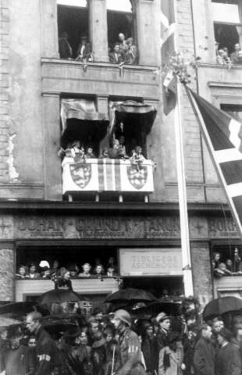 Fra Oslo under fredsdagene i 1945.Fra feiringen langs Karl Johans gate. Bygninger og publikum pytntet for anledningen.