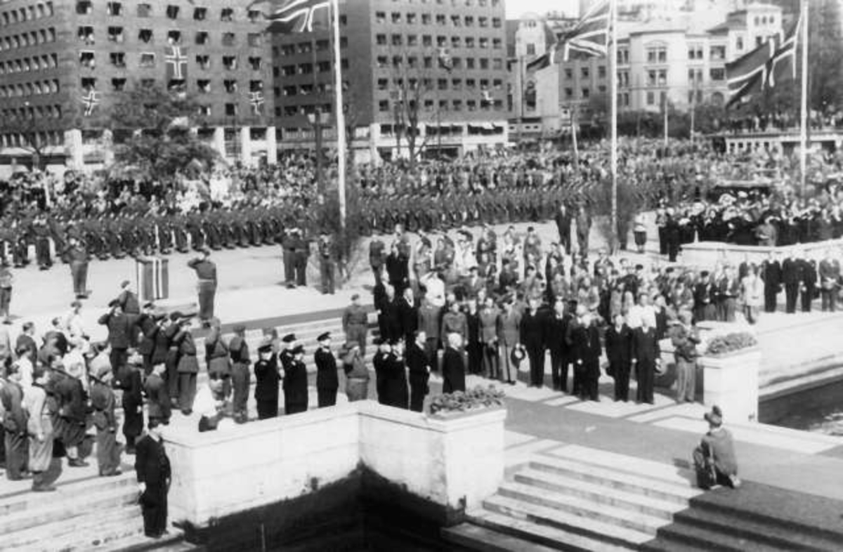 Fra Oslo under fredsdagene i 1945.
Den 13.mai kommer Kronprins Olav tilbake.Bildet viser mottagelsen på Hønnørbrygga, og Rådhusplassen med publikum, fotografer,hjemmefrontkarer og politisoldater.