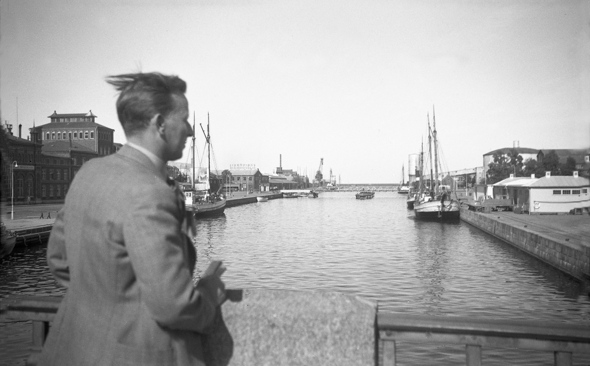 Direktør Trygve Brekke ser ut over havneområdet i Linköping i Sverige. Fotografert under en biltur i Danmark og Sverige 1947.