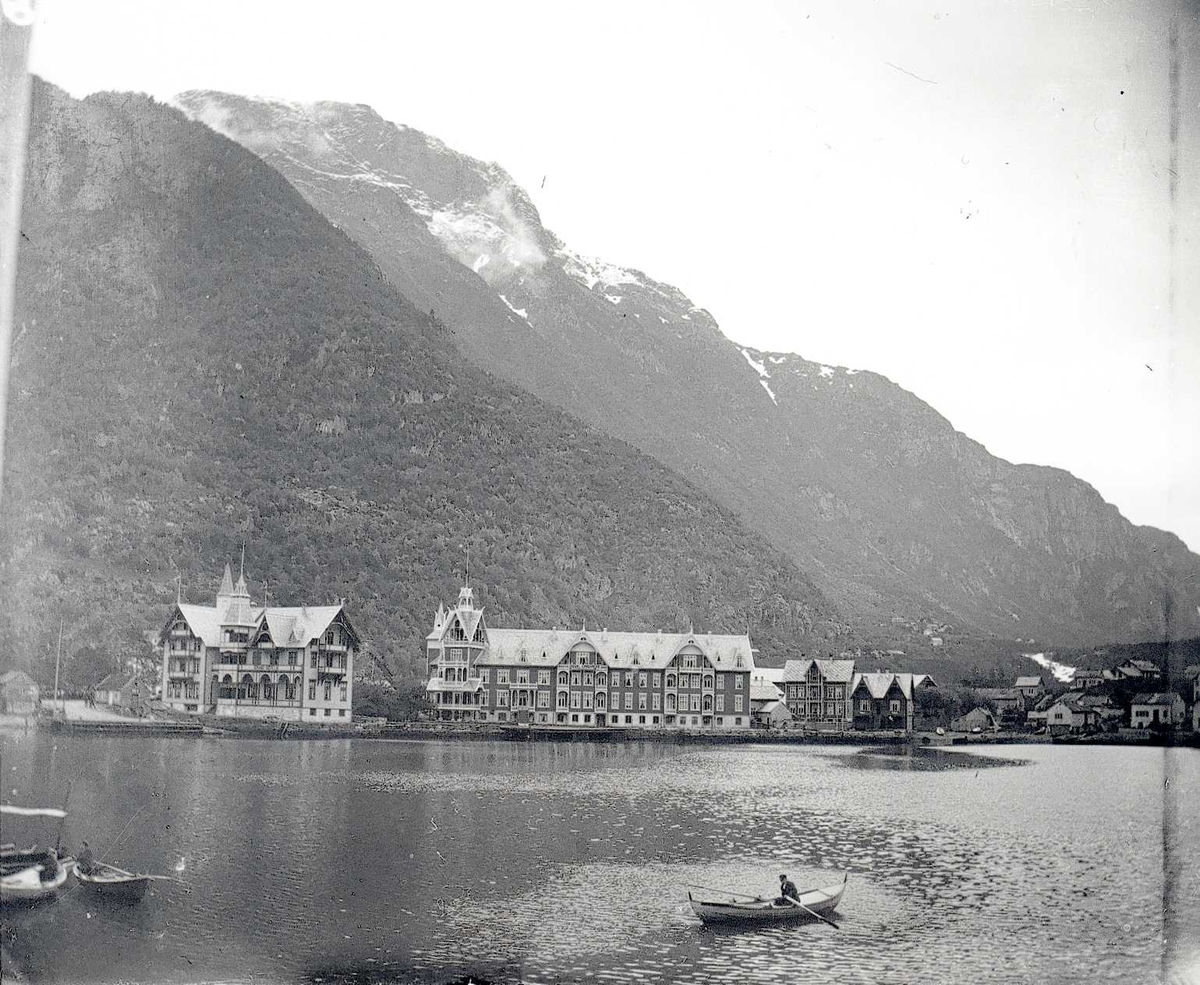 Bilde fra sjøen mot Hotell Hardanger og Odda. Tre robåter på sjøen.