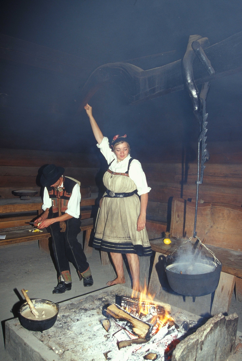 Verter i drakter ved åra i Sagastua, bygning nummer 15 på Norsk Folkemuseum, der det brygges mjød.