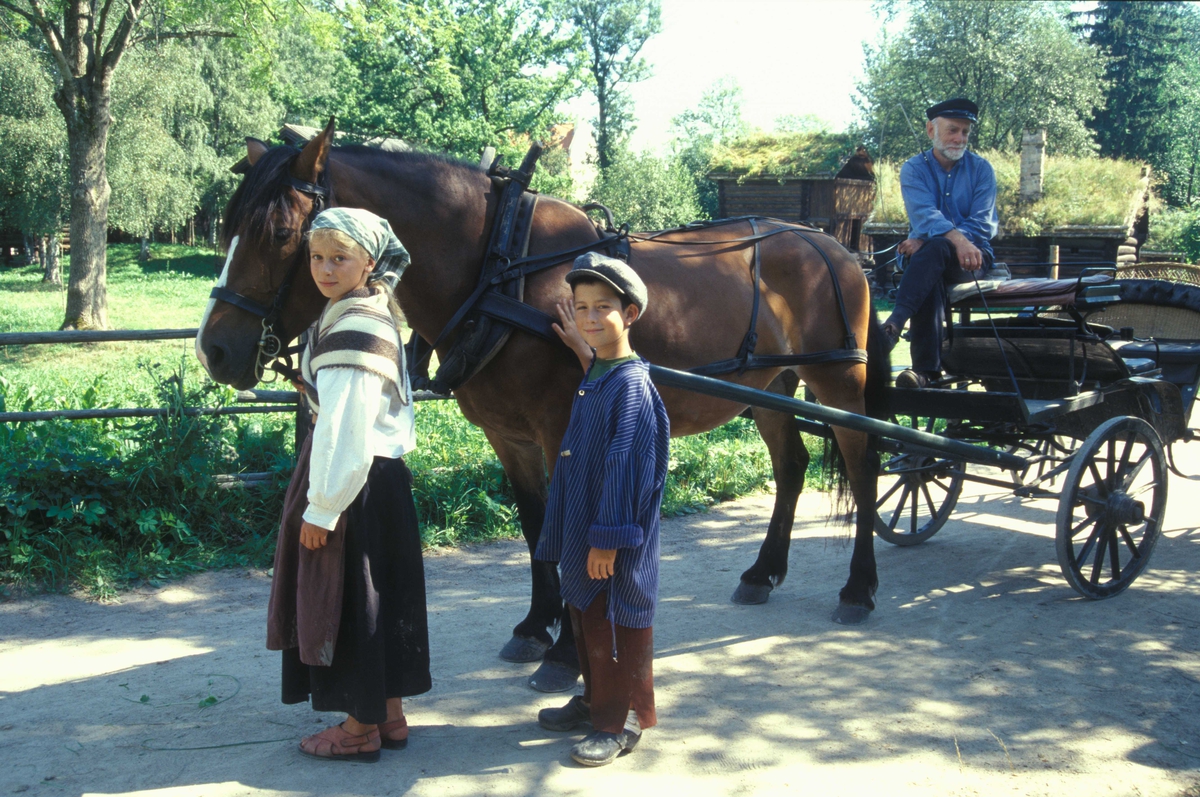 Levendegjøring på museum.
Ferieskolen august 2002
Gutt og jente sammen med hesten og skysskaren i friluftsmuseet.
Norsk Folkemuseum, Bygdøy.