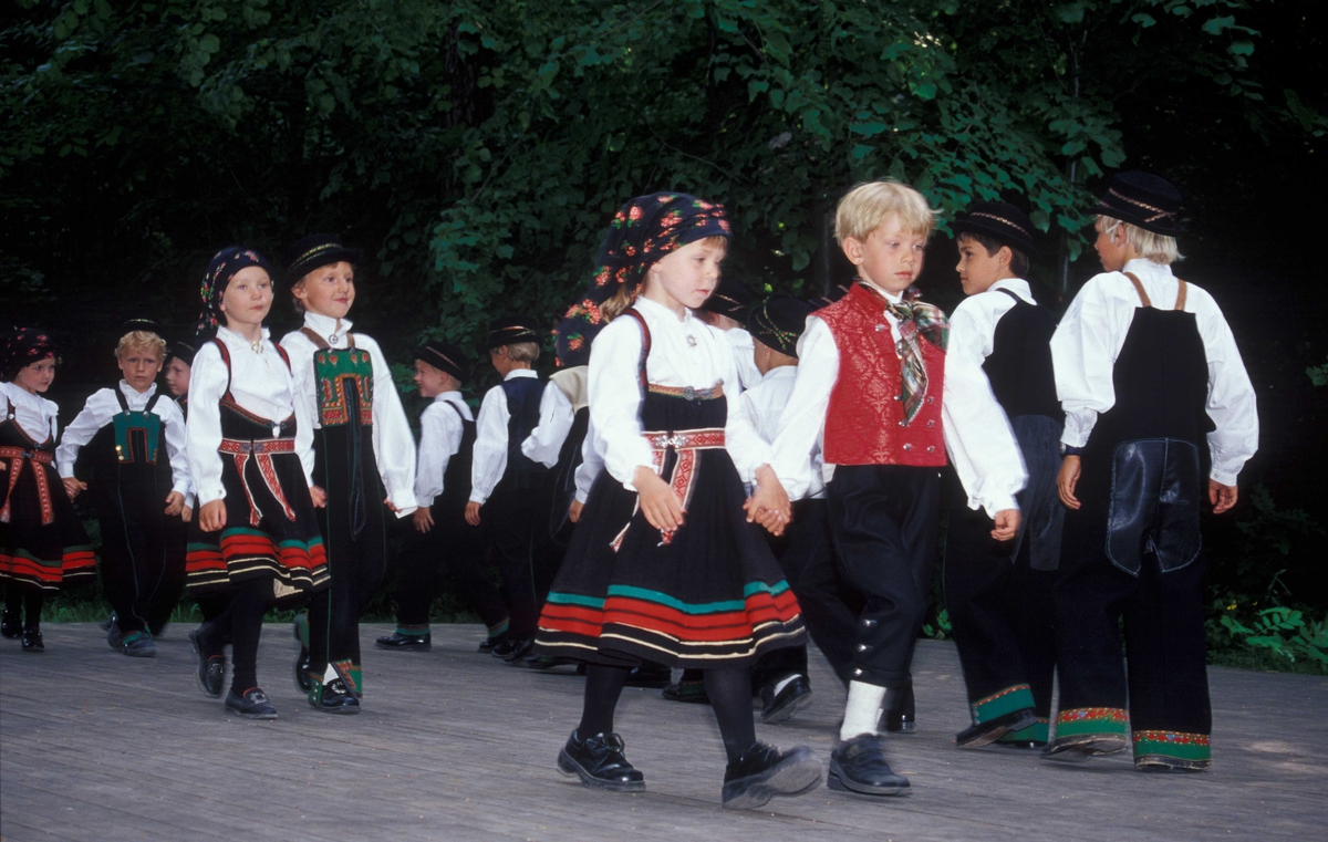 Norsk Folkemuseums dansegruppe, kledd i folkedrakter, danser folkedans i friluftsteateret NF 349.