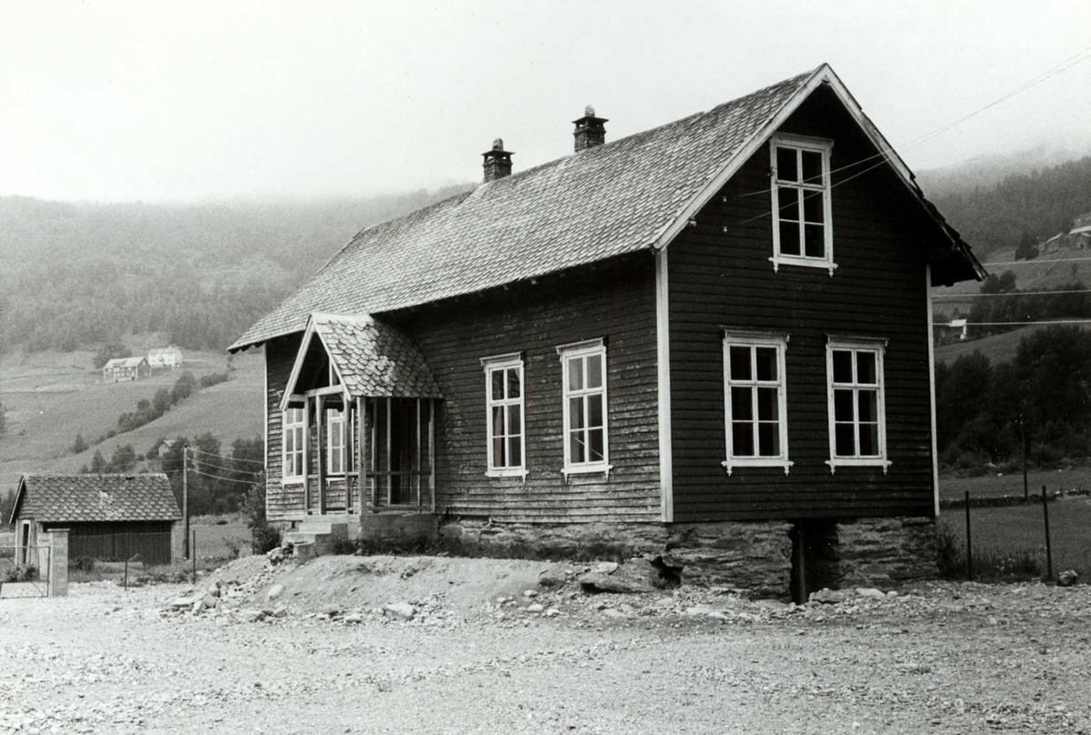 Sundve, Vossastrand, Voss, Hordaland. Mørkt skolehus med hvite kanter og veranda, sett fra gårdsplassen. Registrering utført 1958-59 av Johan Schiong for Noregs Lærarlag. 